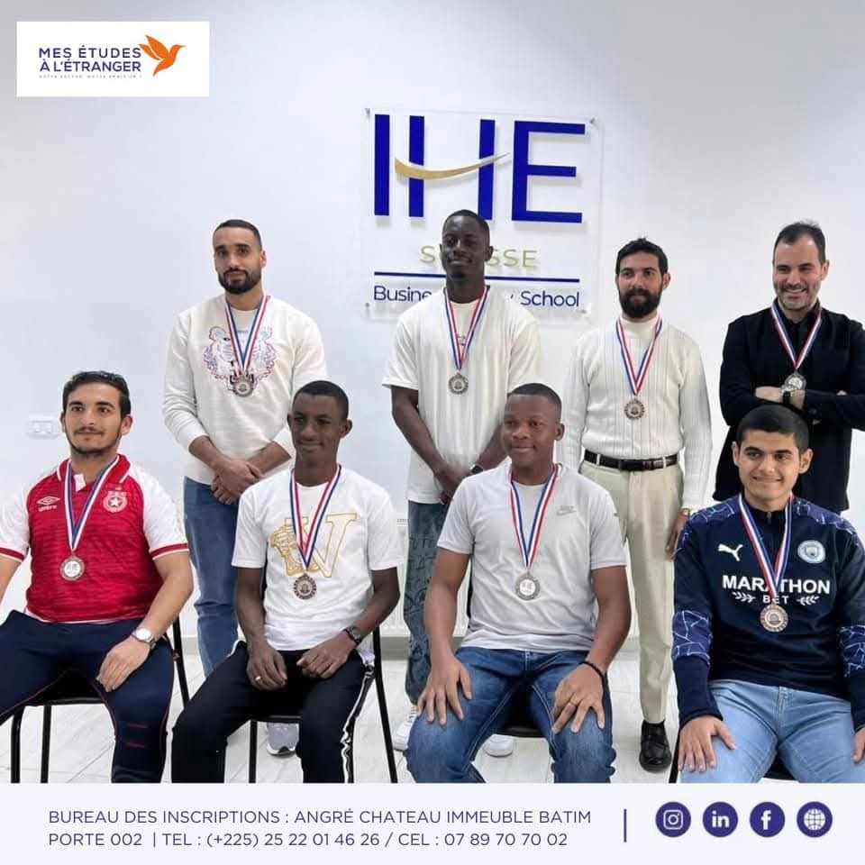 Groupe d'étudiants du Groupe IHE Tunisie posant avec leurs médailles devant le logo IHE Sousse Business & Law School